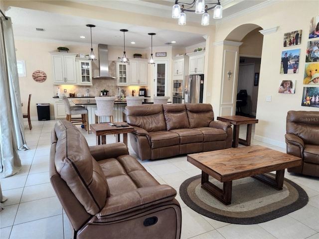 living room with ornate columns, an inviting chandelier, light tile patterned flooring, and ornamental molding