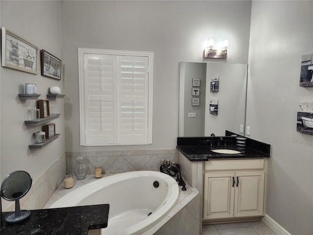 bathroom with tile patterned flooring, vanity, and tiled tub