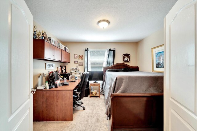 bedroom with a textured ceiling and light carpet