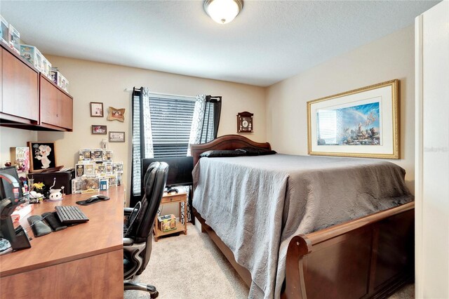 bedroom featuring light carpet and a textured ceiling