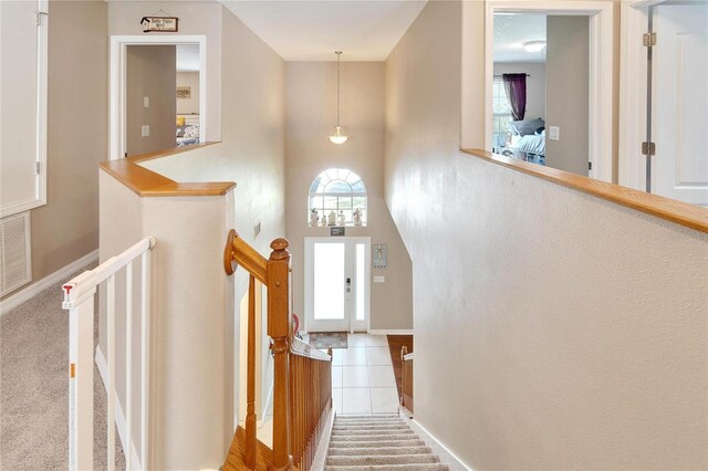 stairway with a high ceiling and carpet