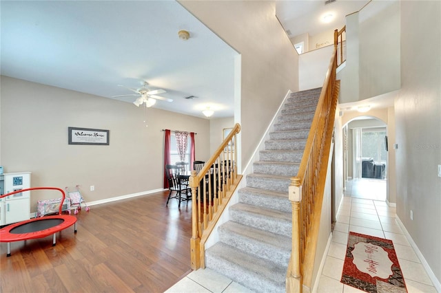 stairway featuring wood-type flooring and ceiling fan