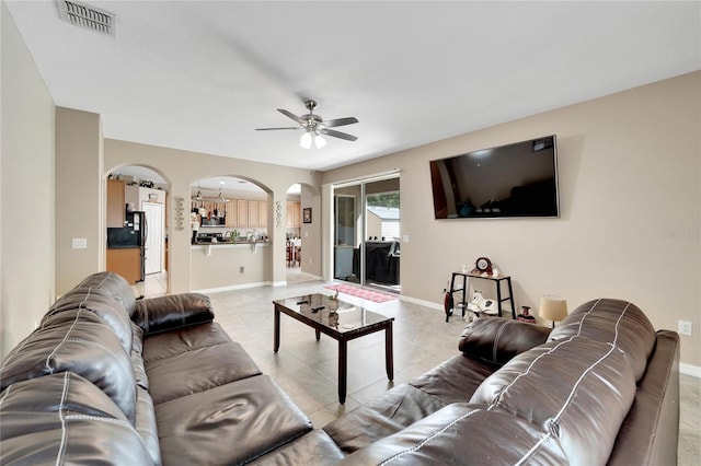 tiled living room with ceiling fan