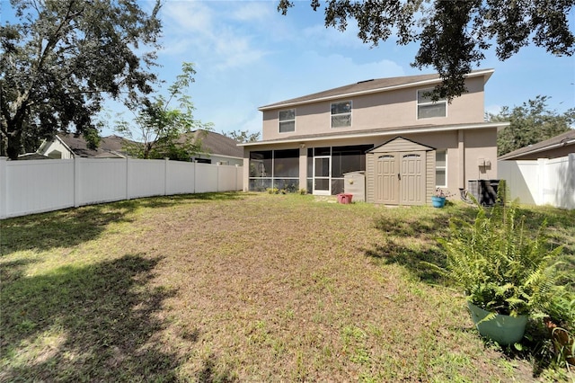 rear view of house with a lawn, a storage unit, and a sunroom