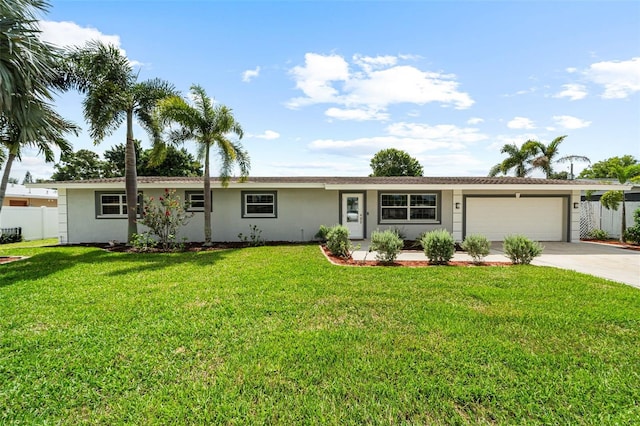 single story home featuring an attached garage, fence, a front yard, stucco siding, and driveway