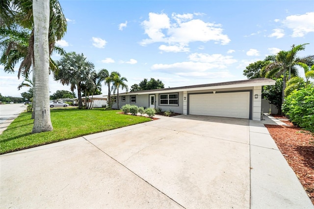 ranch-style home featuring a garage, stucco siding, concrete driveway, and a front lawn