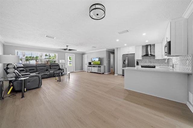 living area featuring ornamental molding, a ceiling fan, recessed lighting, light wood finished floors, and baseboards