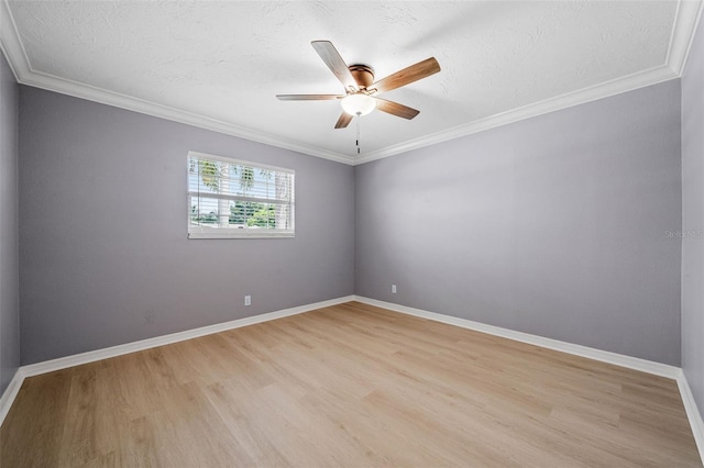 spare room featuring baseboards, light wood-style floors, a ceiling fan, and ornamental molding