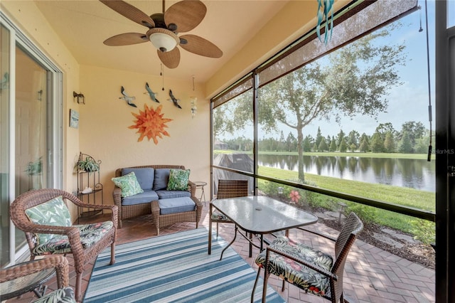 sunroom featuring a water view and ceiling fan