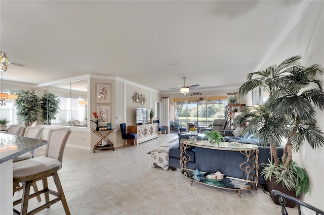 living area featuring a ceiling fan, a wealth of natural light, crown molding, and light tile patterned floors