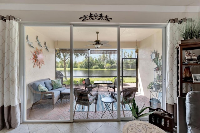 sunroom with a water view and ceiling fan