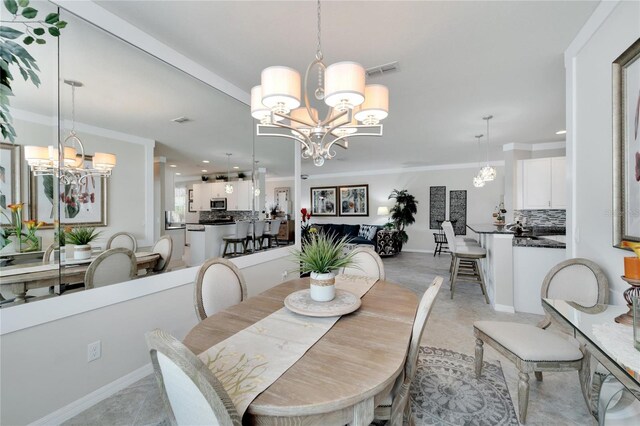 dining space with crown molding, visible vents, and a notable chandelier