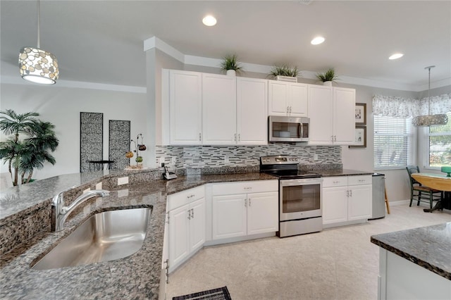 kitchen with decorative backsplash, white cabinets, appliances with stainless steel finishes, dark stone countertops, and a sink