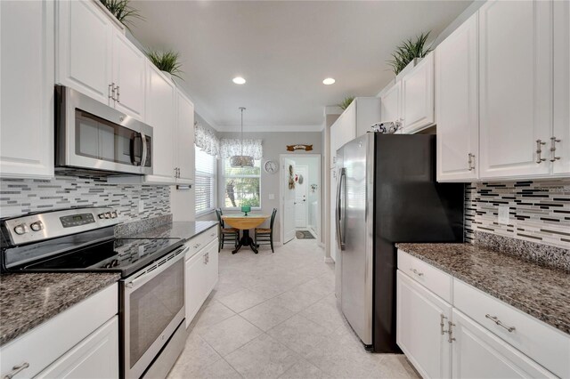 kitchen with stainless steel appliances, crown molding, white cabinetry, backsplash, and light tile patterned flooring