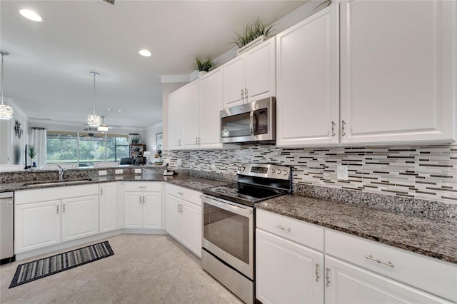 kitchen with decorative light fixtures, appliances with stainless steel finishes, white cabinetry, and sink