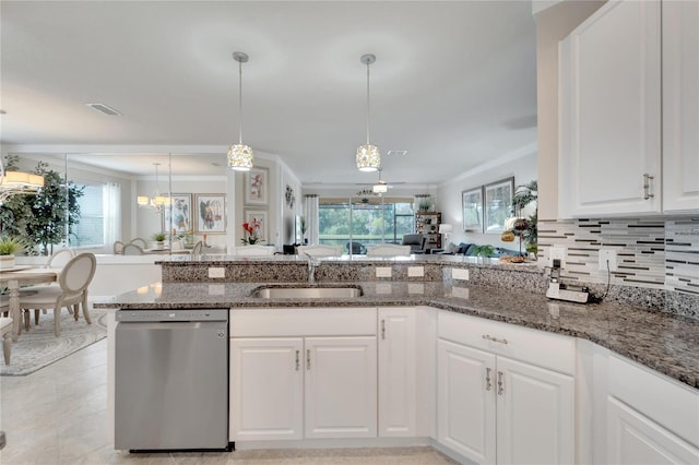 kitchen with plenty of natural light, dark stone counters, dishwasher, and a sink