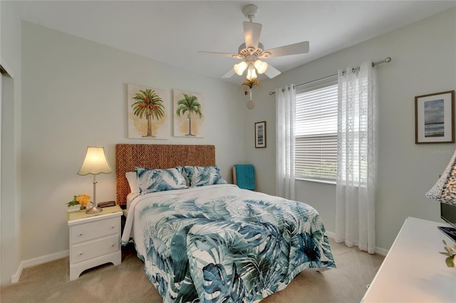 bedroom featuring light carpet, a ceiling fan, and baseboards