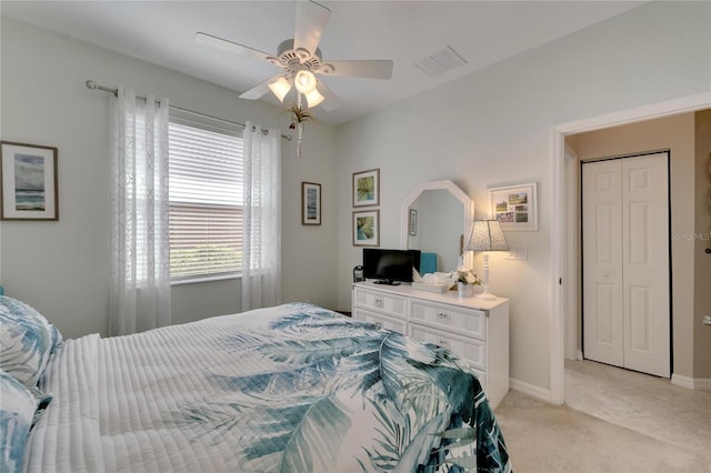 carpeted bedroom featuring ceiling fan and a closet