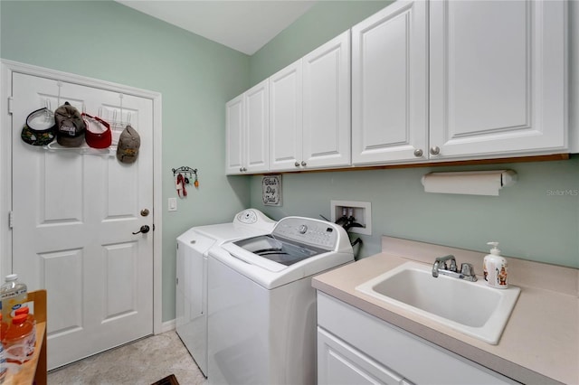 clothes washing area featuring cabinet space, a sink, and washing machine and clothes dryer