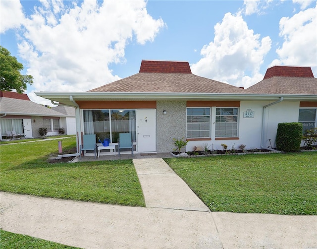 single story home featuring a front yard and a patio area