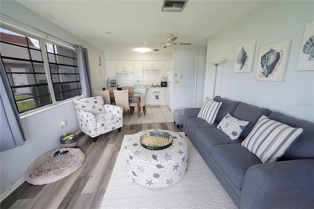 living room featuring hardwood / wood-style floors, ceiling fan, a wealth of natural light, and a textured ceiling