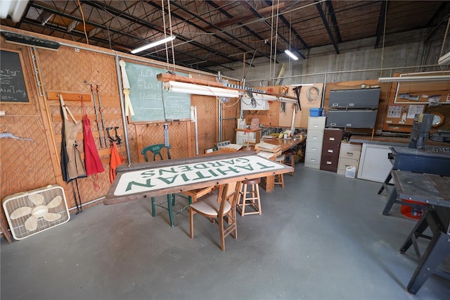 garage with a workshop area and wooden walls