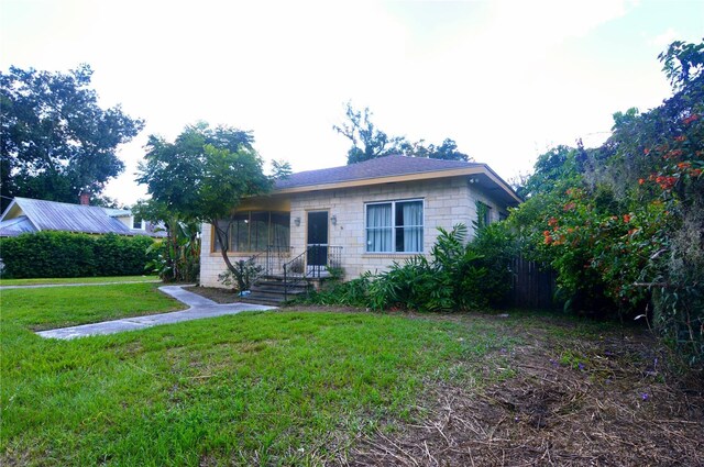 view of front of house featuring fence and a front lawn
