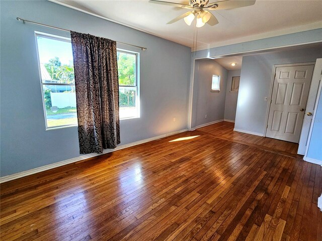 spare room with ceiling fan, baseboards, and hardwood / wood-style flooring