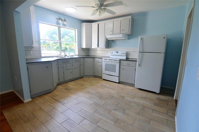 kitchen with a sink, ceiling fan, white appliances, under cabinet range hood, and backsplash