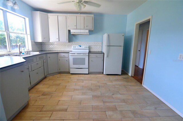 kitchen featuring tasteful backsplash, a sink, ceiling fan, white appliances, and under cabinet range hood