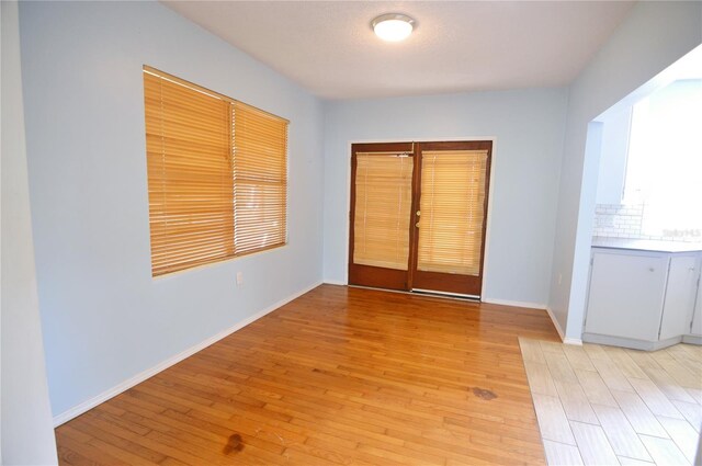 empty room with light wood-style floors and baseboards