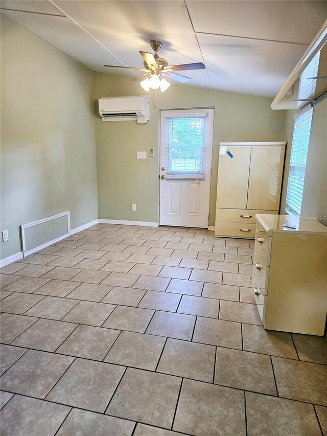 interior space featuring visible vents, ceiling fan, baseboards, and a wall mounted air conditioner