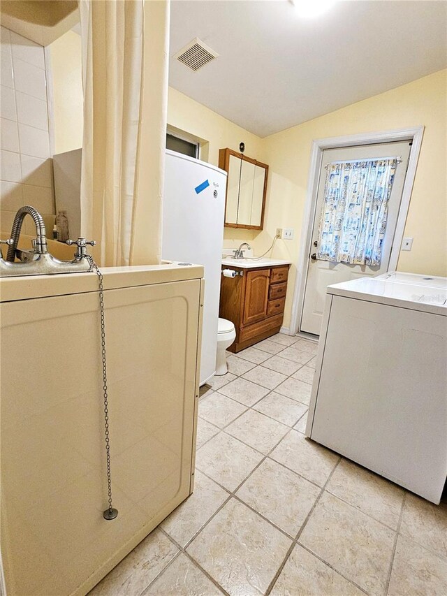 washroom with washer / clothes dryer, visible vents, laundry area, and a sink