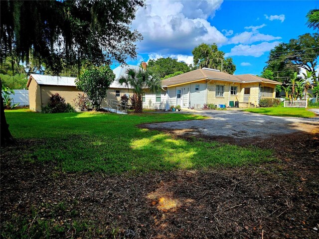 back of property with fence and a lawn