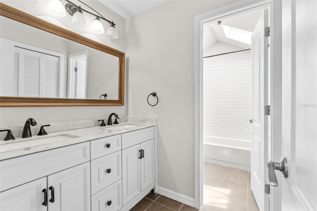 bathroom with lofted ceiling, vanity, tile patterned floors, and washtub / shower combination