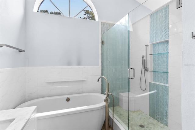 bathroom with tile walls, separate shower and tub, and vanity