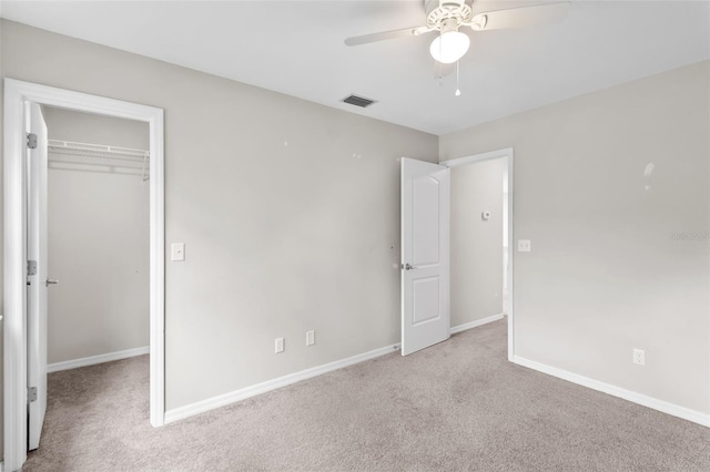 unfurnished bedroom featuring ceiling fan, light colored carpet, and a closet