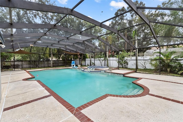 view of swimming pool with an in ground hot tub, glass enclosure, and a patio