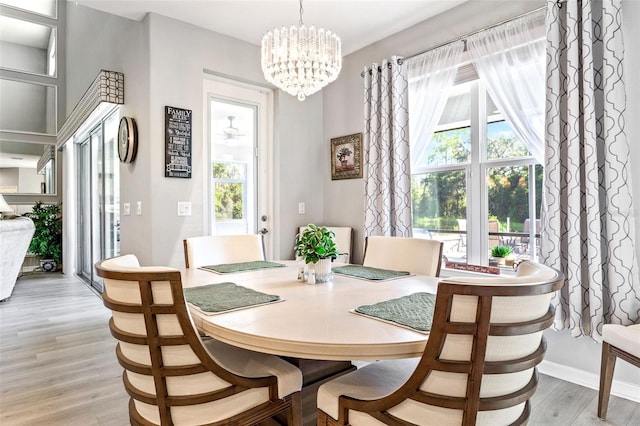 dining room featuring light wood-type flooring and an inviting chandelier