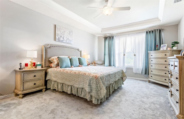 bedroom featuring ceiling fan, light colored carpet, and a raised ceiling