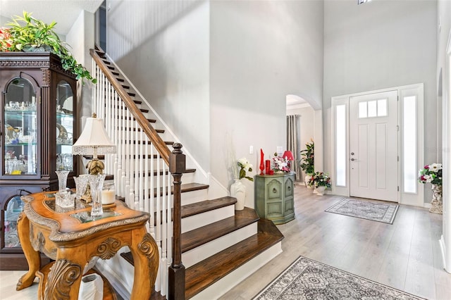 entryway featuring a high ceiling and light hardwood / wood-style floors