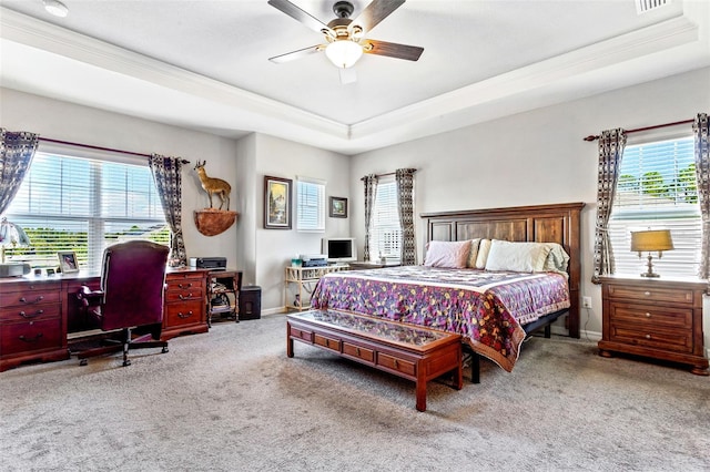 bedroom with ceiling fan, light colored carpet, a raised ceiling, and ornamental molding