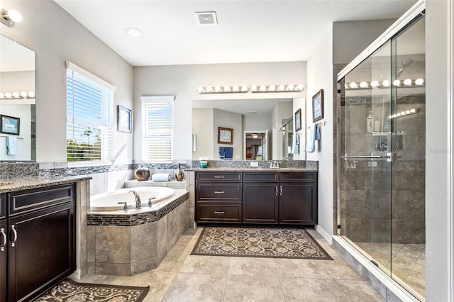 bathroom with tile patterned floors, independent shower and bath, and vanity