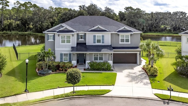 view of front of home with a water view, a garage, and a front lawn