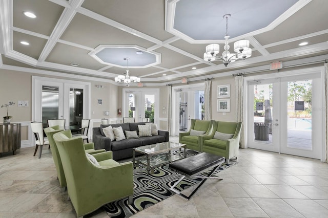 living room featuring an inviting chandelier, ornamental molding, coffered ceiling, and french doors