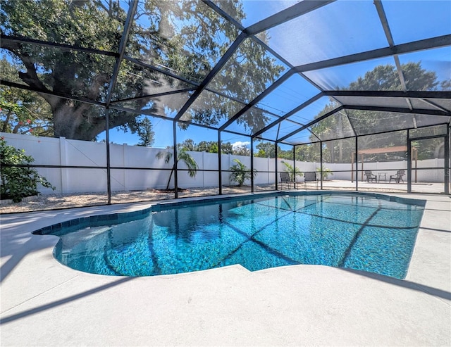 view of swimming pool with glass enclosure and a patio area