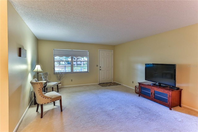 living area with light carpet and a textured ceiling