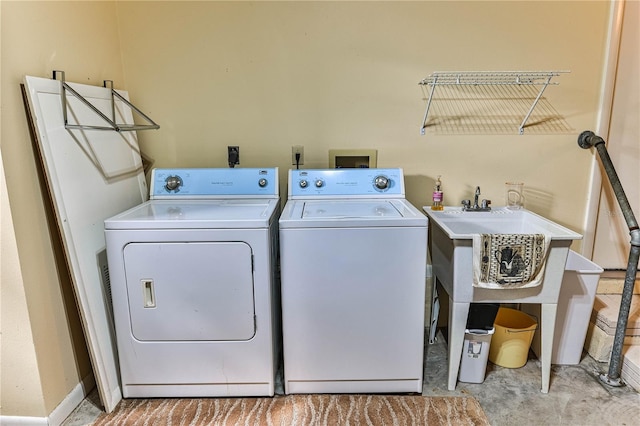 laundry area with washing machine and clothes dryer and sink