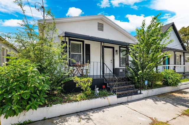 bungalow featuring covered porch and central AC unit