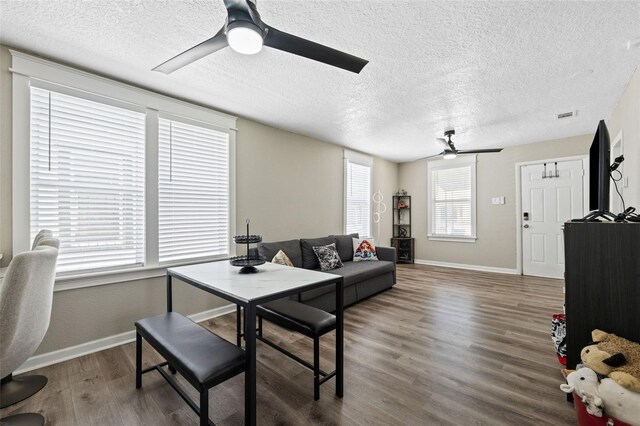 living room featuring a textured ceiling, ceiling fan, and hardwood / wood-style floors